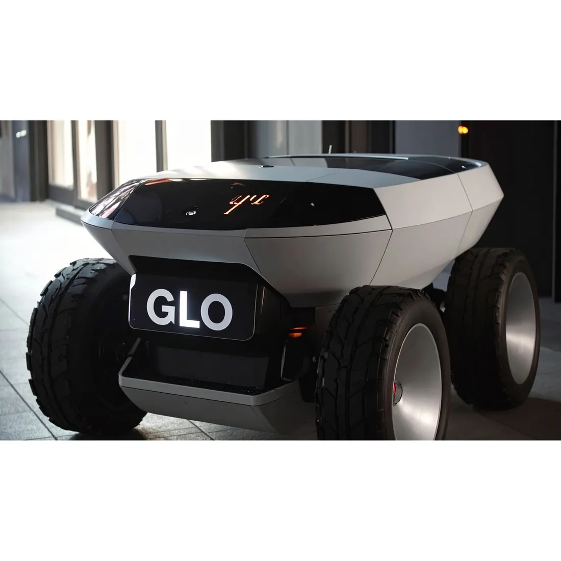An autonomous GLO delivery robot on a city street at night